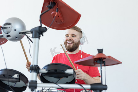 鼓手、爱好和音乐概念 — 身穿红色衬衫的年轻男鼓手演奏电子鼓
