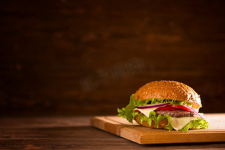 深色背景中木桌上木板上的汉堡