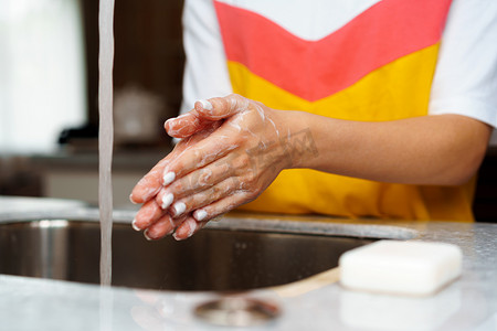 水里细菌摄影照片_一个女人在厨房水槽里洗手的特写