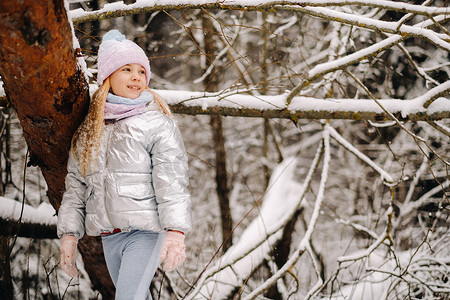 小女孩冬天摄影照片_冬天穿银色夹克的小女孩冬天出门
