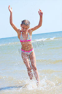 快乐漂亮的女孩在海滩上奔跑