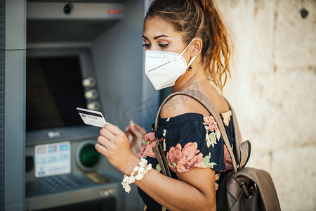 n95摄影照片_使用 ATM 的戴防护面具的女人