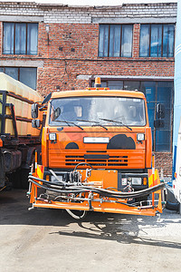 卡货车摄影照片_卡玛斯卡车停在砖砌建筑背景的停车场里