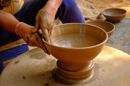陶器 — 陶工熟练的湿手在陶轮上塑造粘土