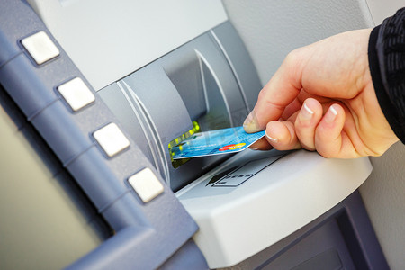 将信用卡插入 ATM 的年轻女子