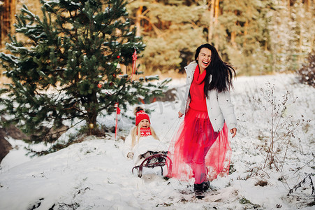 情绪化的女孩在白雪皑皑的森林里雪橇一个小女孩。冬天的心情
