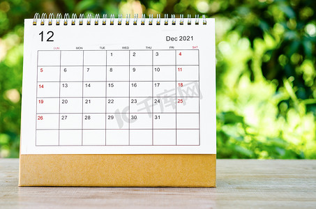 2021日历摄影照片_2021 年 12 月日历台，供组织者在木桌上计划和提醒。