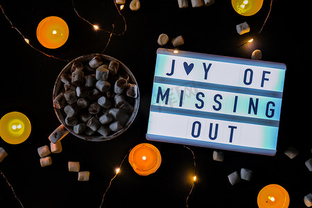 out摄影照片_带有文本 JOMO Joy of Missing Out 的灯箱。