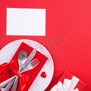 情人节餐设计理念-浪漫的盘子设置隔离在红色背景上，用于餐厅、节日庆典促销、顶视图、平躺。