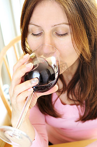 拿红酒摄影照片_成熟的女人拿着一杯红酒
