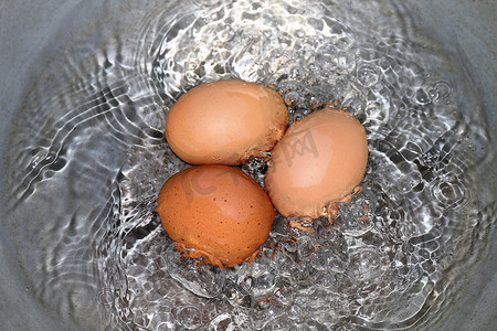 鸡蛋，锅里的煮鸡蛋，热水中的生鸡蛋红黄色正在煮沸（选择性聚焦）