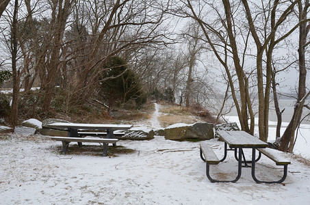 野餐桌摄影照片_波托马克河沿岸带小径和雪的木野餐桌