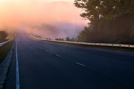 未知世界摄影照片_有护栏的河流附近夏季高速公路上的清晨浓雾