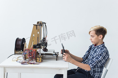 教育、儿童、技术概念-青少年男孩正在 3D 打印机上打印。
