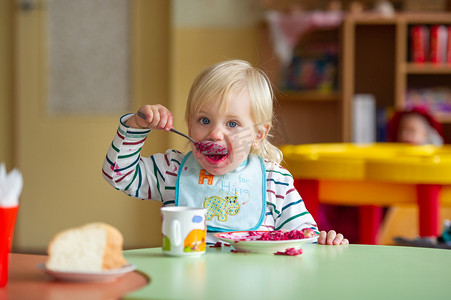 幼儿园食品摄影照片_孩子在幼儿园或家里吃健康食品弄脏了