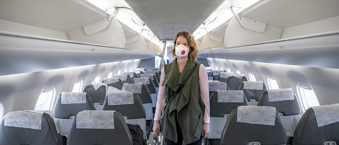 头戴呼吸器的飞机上的妇女。