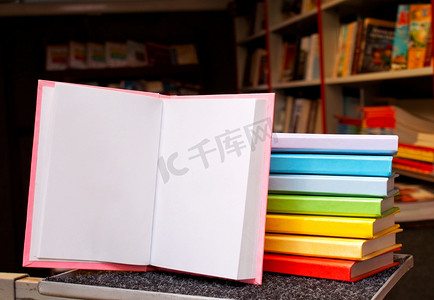 一堆书本摄影照片_打开书本，后面有一堆彩色书籍