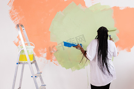 美国黑人妇女粉刷公寓。