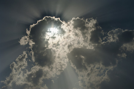 太阳光线摄影照片_阳光穿过暴风雨天空中的云层