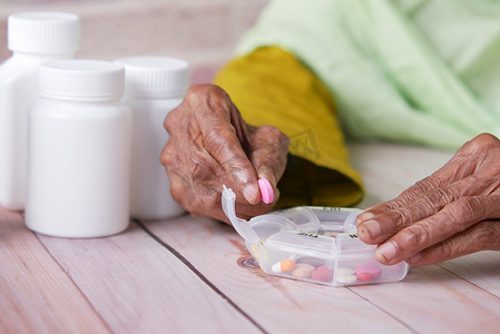 老年妇女手从药盒中取药