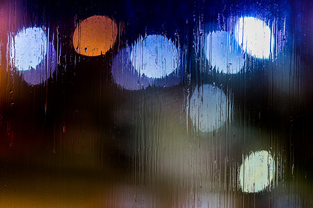 抽象背景夜路灯透过湿玻璃散景，特写有选择的焦点