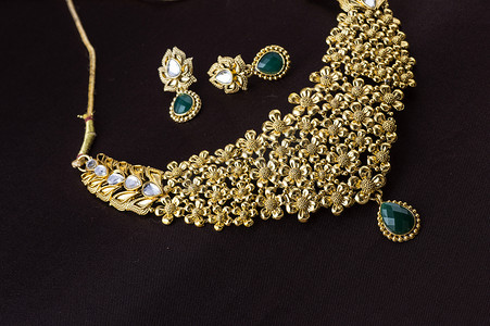 时尚深色背景摄影照片_印度传统珠宝，深色背景下垂饰的特写