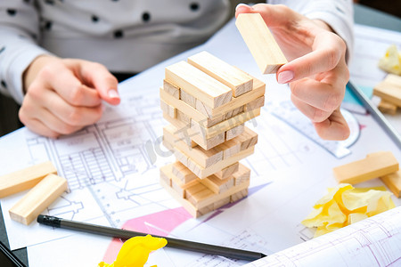 建筑师设计师室内创意工作手在房子的办公桌建筑计划上玩木块游戏，调色板。
