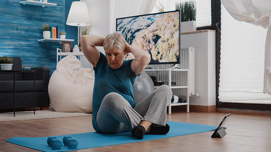 老年人在平板电脑上进行体育锻炼和观看视频