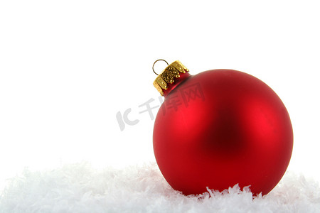 红色小雪花摄影照片_雪中​​的红色圣诞小玩意