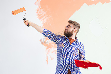 男性用油漆滚筒粉刷墙壁。