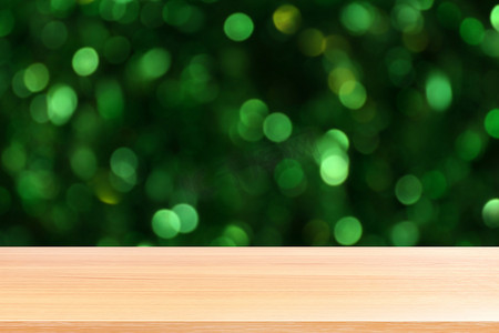 木板照明美丽闪闪发光的绿色散景背景，空木桌地板在阳光下照明绿色自然森林散景，木桌板空前绿色闪光背景灯