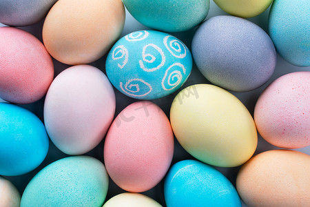 设计淡蓝色背景摄影照片_五颜六色的复活节彩蛋由淡蓝色背景上的彩色水染成，复活节假期活动的设计理念，特写，复制空间。