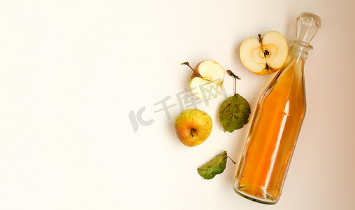 苹果树远景摄影照片_一瓶苹果醋和苹果果实组成。