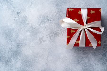 灰色磨砂背景的红色圣诞礼品盒