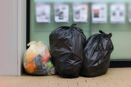 三个垃圾袋，垃圾袋黑色放置在便利店前，垃圾桶，垃圾桶，垃圾袋，人行道上的垃圾，地板上的垃圾袋三袋垃圾桶，成堆的垃圾，成堆的黑色垃圾袋