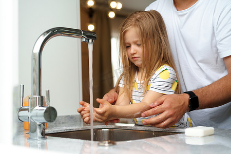 水槽洗手摄影照片_父亲和女儿在厨房的水槽上方洗手