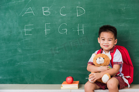 背书包书包摄影照片_来自幼儿园的儿童男孩穿着学生制服和书包 s