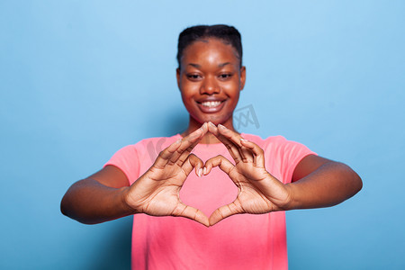 非洲裔美国年轻女性用手指制作心形符号的肖像