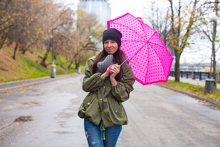 秋雨天打伞行走的年轻女子