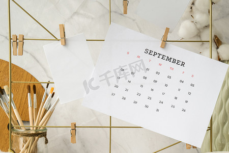 9 月日历卡片和海报模型在网格板上。