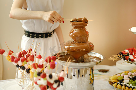 带有巧克力喷泉和糖果的火锅。甜蜜的主题