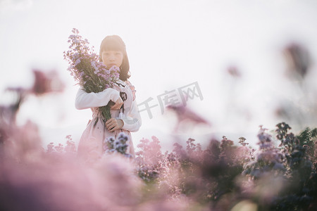 紫色花朵背景摄影照片_有紫色花朵背景的肖像亚洲女孩