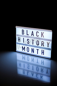 黑人历史月摄影照片_带有镜面反射的深黑色背景上带有文本“黑人历史月”的灯箱。