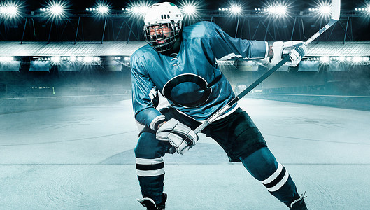 冰球运动员戴着头盔和手套在体育场上拿着棍子。