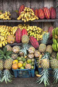 秘鲁水果摄影照片_柜台上的可可果被其他热带水果包围