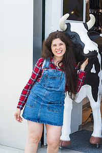 开朗的年轻女人，在商店前有一尊牛头雕像