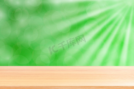 空木桌地板在柔和的绿色散景灯光束闪耀渐变背景，木板空在绿色散景多彩光闪耀，彩色散景灯渐变柔和用于横幅广告