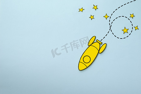 蓝色背景中环绕星星的黄色小火箭