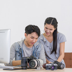 记者编辑摄影照片_亚洲摄影师和模特看着相机屏幕上拍摄的照片。