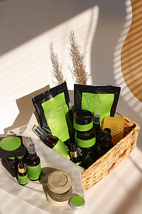柳条篮中的化妆品瓶、罐子和自制包装，带有品牌绿色空间。